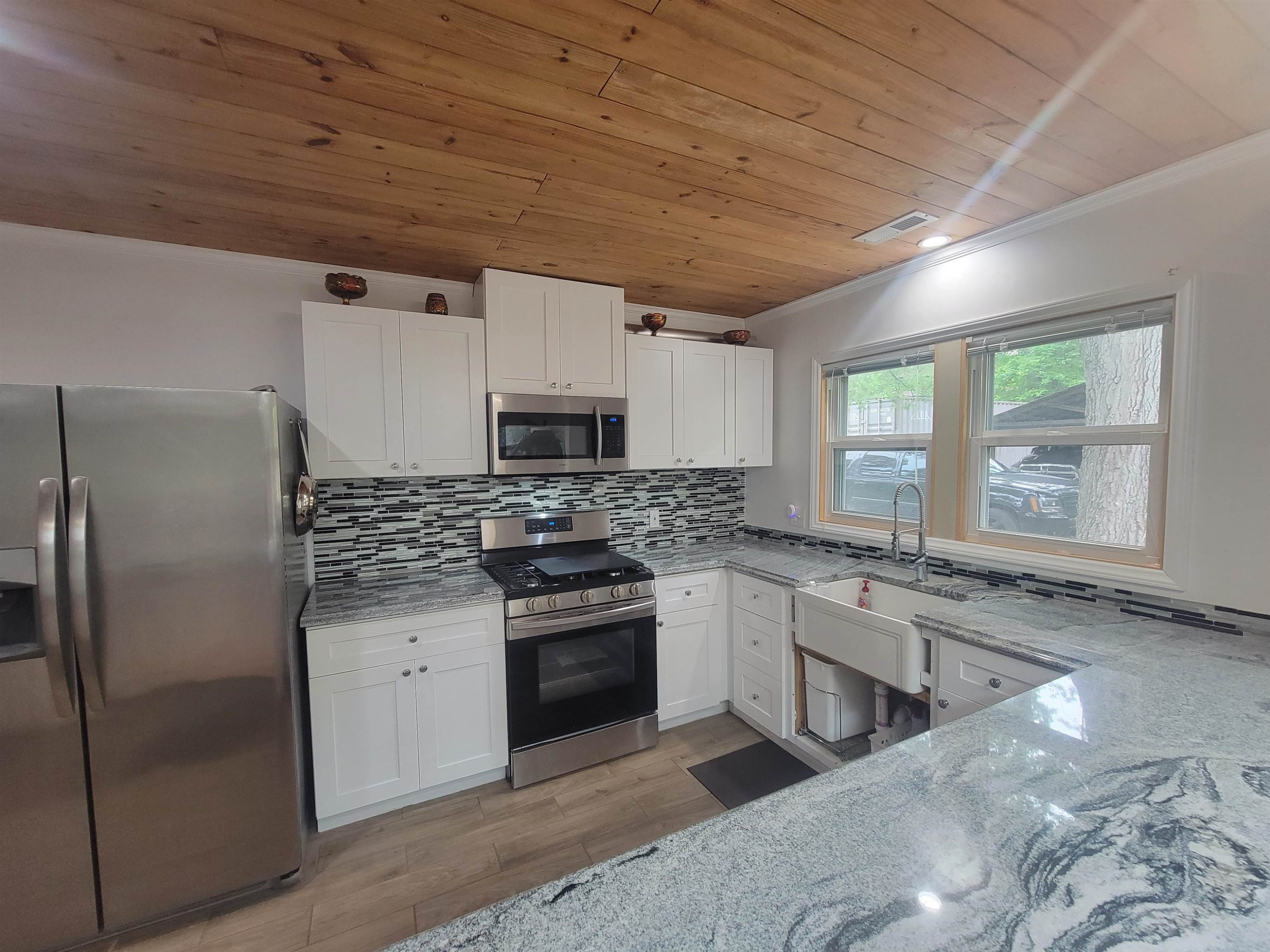 3217 Rowena Avenue Durham, NC 27703 - Photo 28 of 30 a kitchen with stainless steel appliances granite countertop a stove a sink dishwasher a refrigerator and a microwave