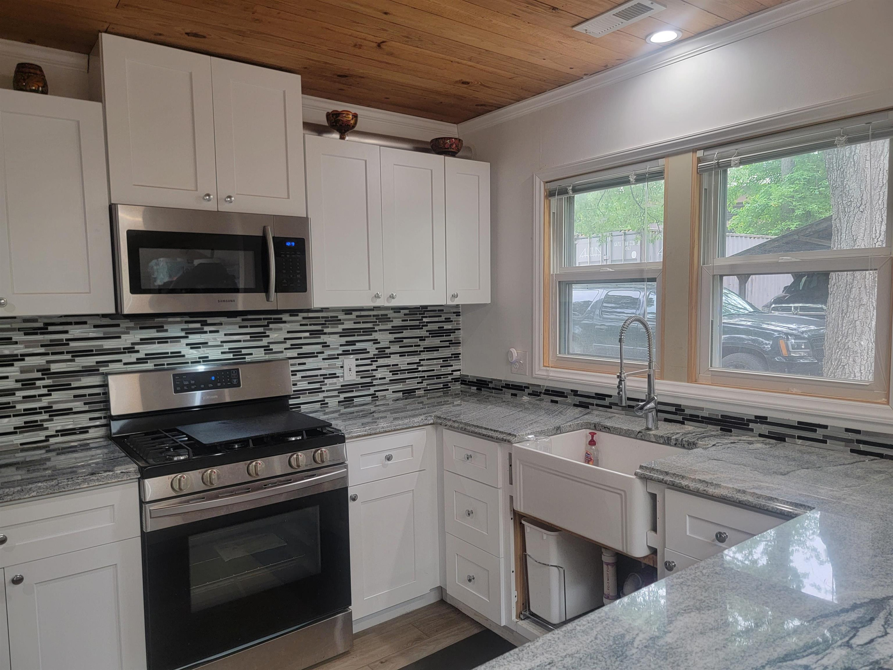 3217 Rowena Avenue Durham, NC 27703 - Photo 29 of 30 a kitchen with granite countertop a stove sink and microwave