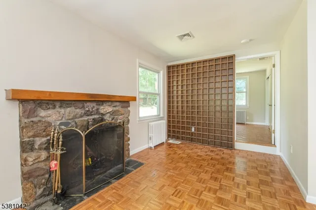 a view of an empty room with a fireplace and a window