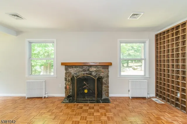 an empty room with windows and fireplace