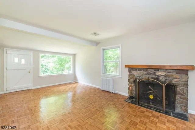 an empty room with windows and fireplace