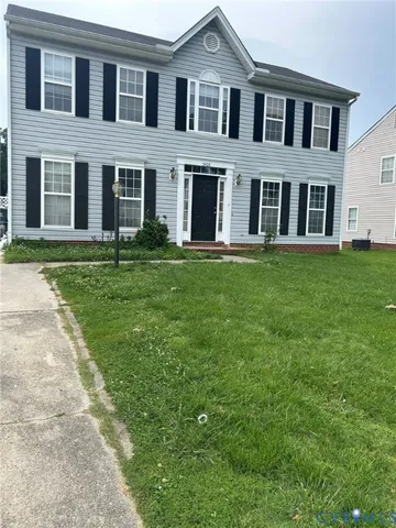 front view of a brick house with a yard