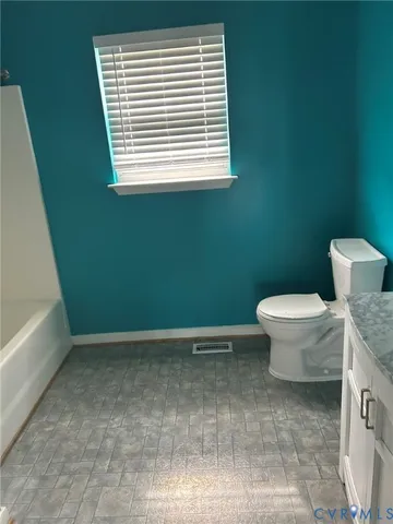 a bathroom with a toilet and a window