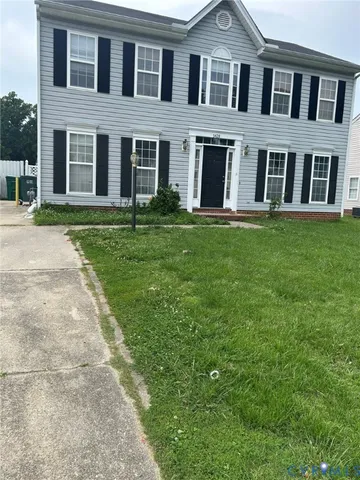 a front view of brick house with a yard