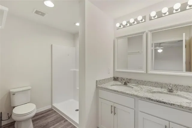 a bathroom with a granite countertop sink a toilet and a mirror