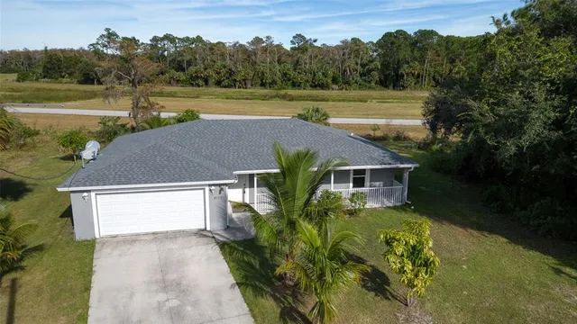 a view of a house with a yard and a pond