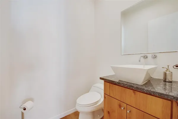 a bathroom with a granite countertop toilet and sink
