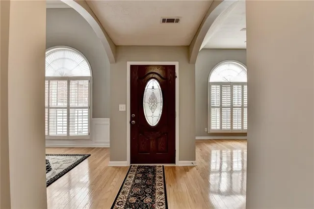 a dining room filled chandelier and wooden floor