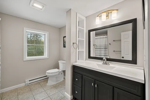 a bathroom with a double vanity sink toilet and a mirror