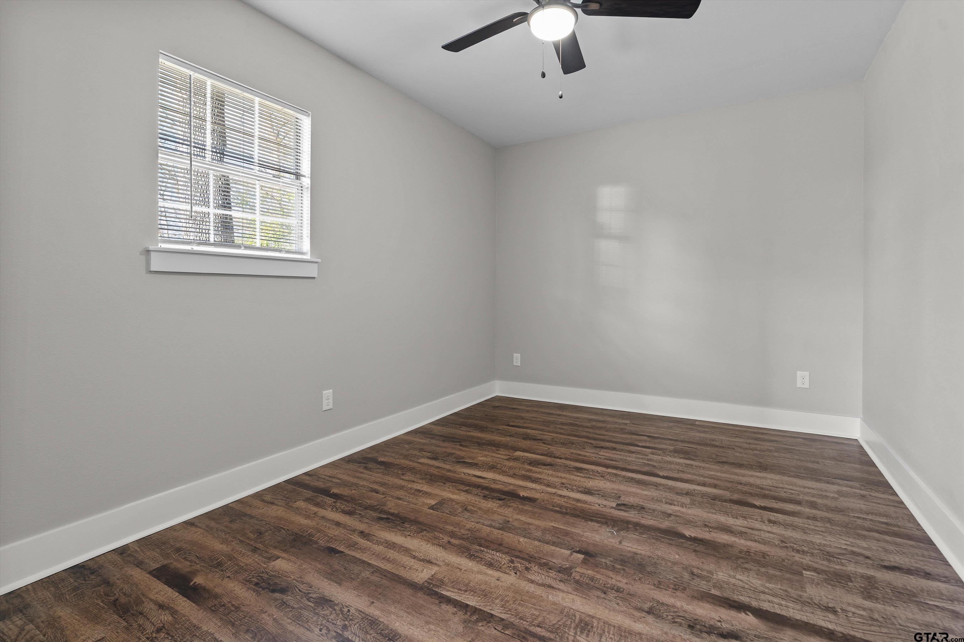 5881 Jefferson Avenue Tyler, TX 75708 - Photo 17 of 20 wooden floor in an empty room with a window