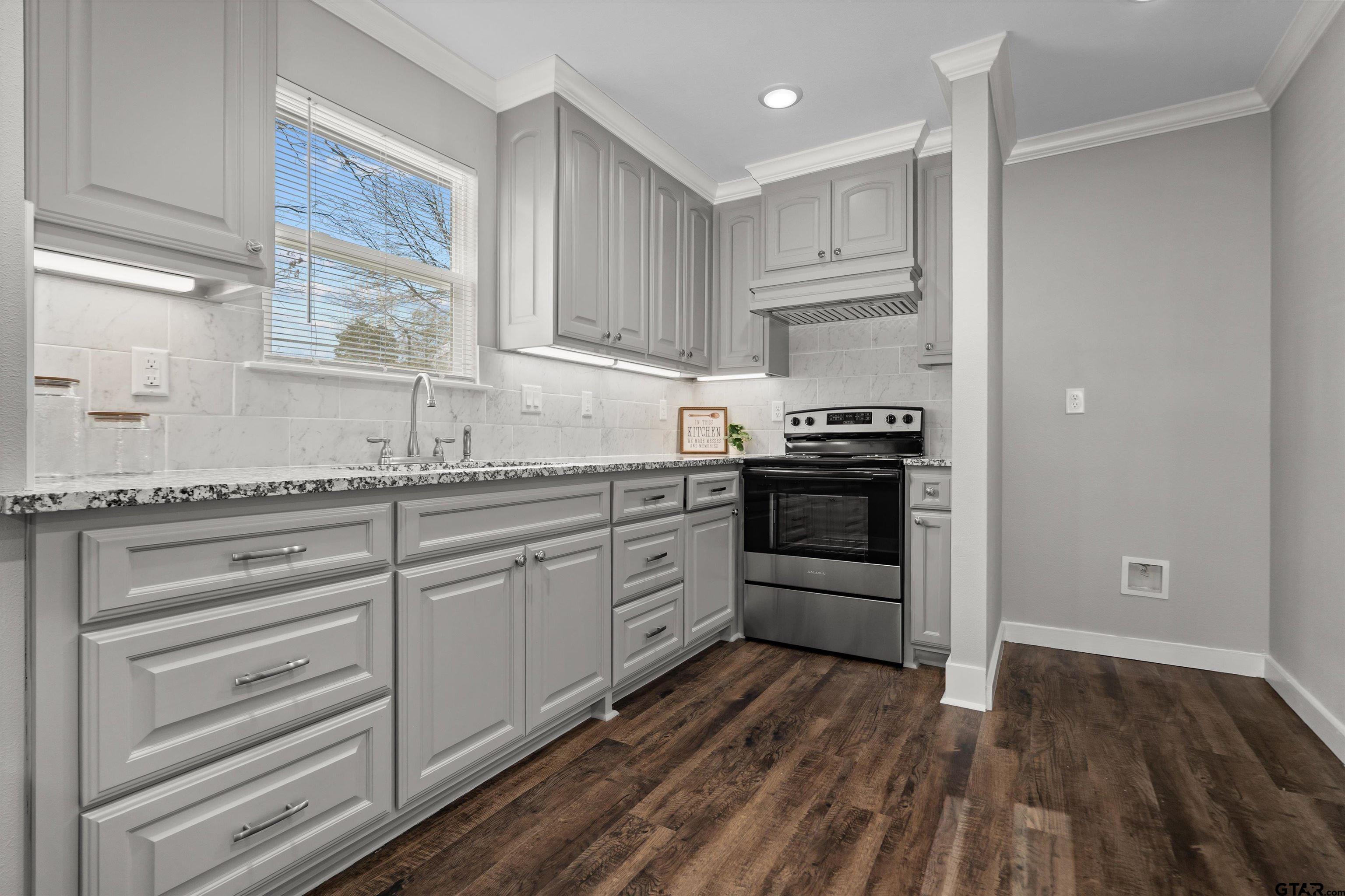 5881 Jefferson Avenue Tyler, TX 75708 - Photo 6 of 20 a kitchen with granite countertop white cabinets and stainless steel appliances