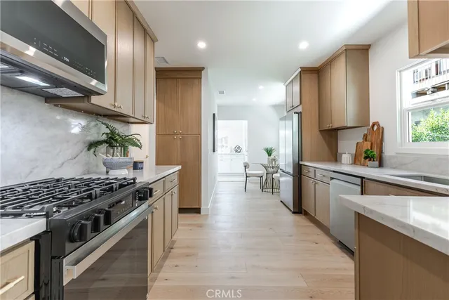 a kitchen with stainless steel appliances a sink stove and cabinets