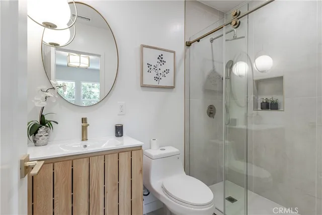 a bathroom with a toilet a sink and a mirror