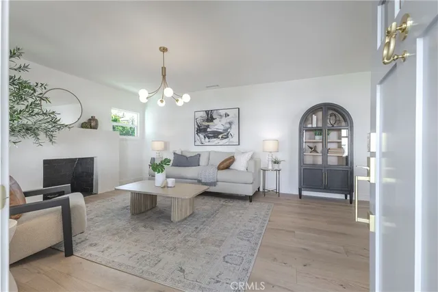 a living room with furniture a fireplace and a chandelier