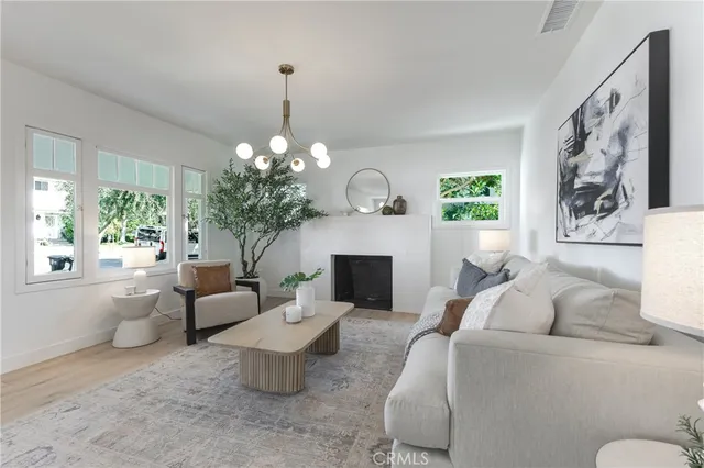 a living room with furniture a chandelier and a fireplace