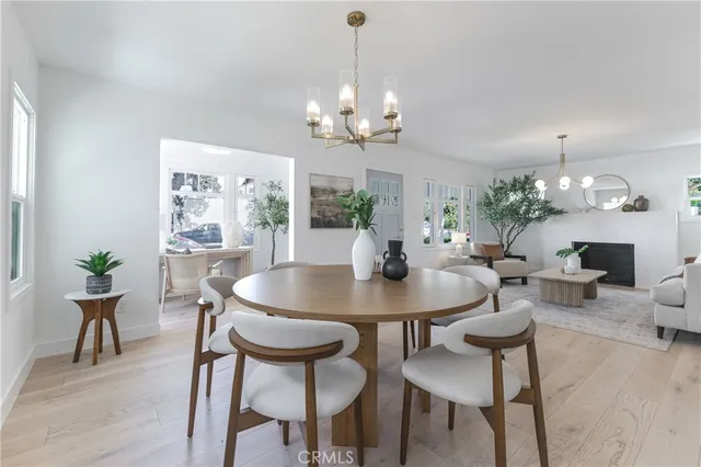 a view of a dining room with furniture a chandelier and wooden floor