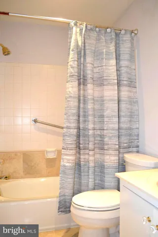a white toilet sitting next to a shower curtain