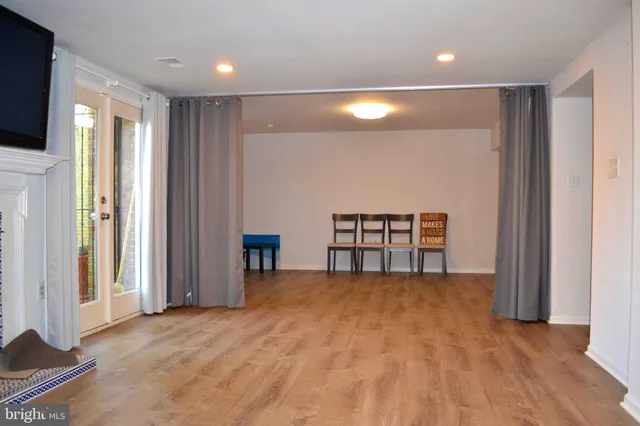a view of an empty room with cabinet and a flat screen tv