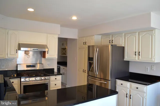 a kitchen with stainless steel appliances a refrigerator a stove and a sink