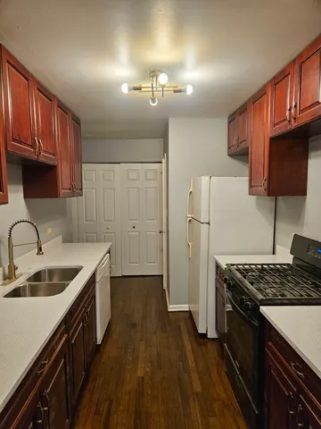 a kitchen that has a sink a stove and a wooden cabinets