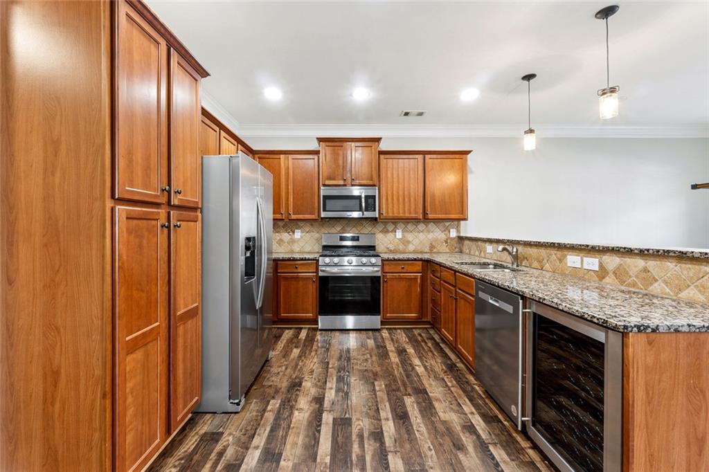 3184 Buck Way Alpharetta, GA 30004 - Photo 8 of 48 a kitchen with stainless steel appliances granite countertop a refrigerator a sink and wooden cabinets