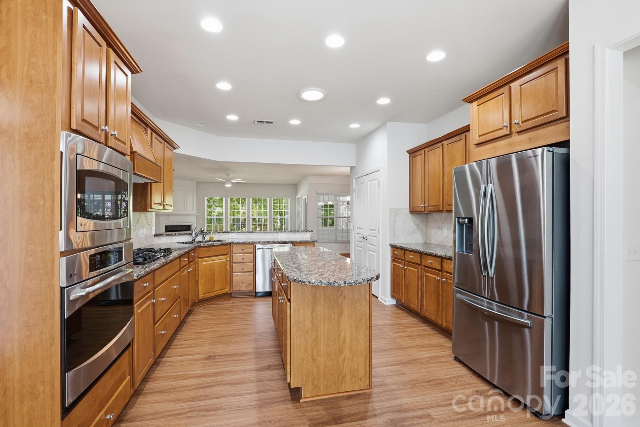 2818 Mandarin Street Fort Mill, SC 29707 - Photo 11 of 48 a kitchen with stainless steel appliances granite countertop a refrigerator a stove top oven a sink dishwasher and wooden cabinets with wooden floor