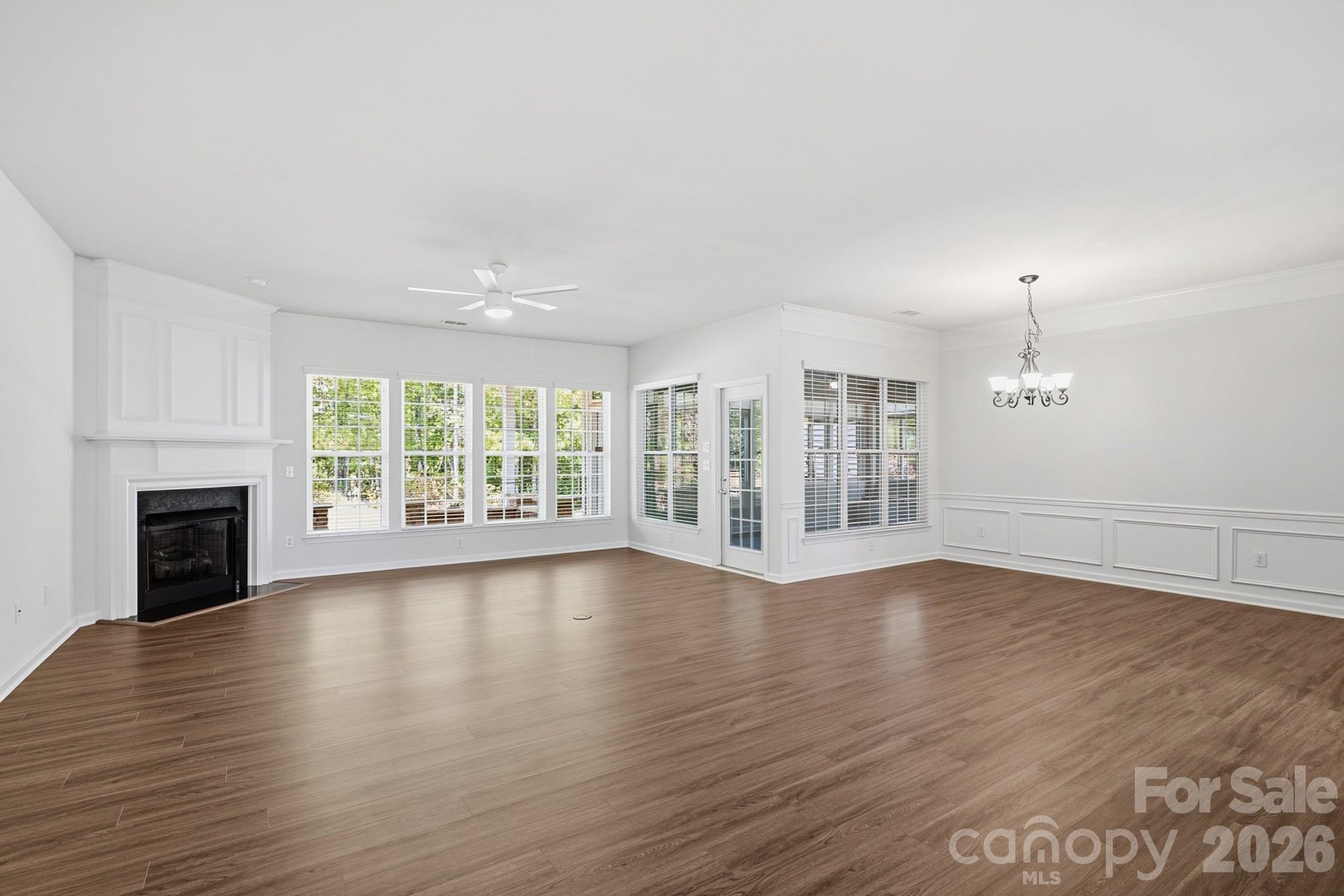 2818 Mandarin Street Fort Mill, SC 29707 - Photo 7 of 48 an empty room with wooden floor fireplace and windows