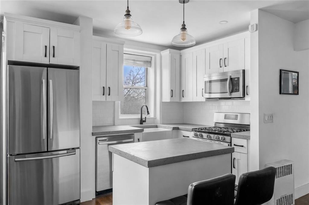 7520 Ridge Boulevard, Unit 2A Brooklyn, NY 11209 - Photo 4 of 15 a kitchen with stainless steel appliances granite countertop a refrigerator a stove a sink and a refrigerator with white cabinets