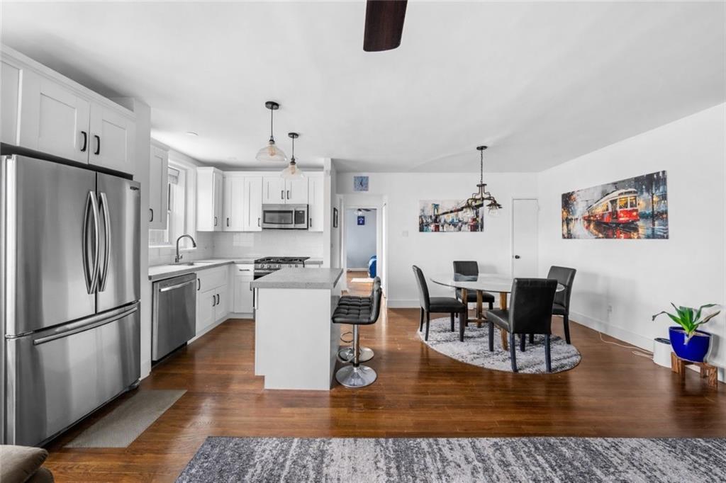 7520 Ridge Boulevard, Unit 2A Brooklyn, NY 11209 - Photo 6 of 15 a kitchen with a dining table chairs refrigerator and sink