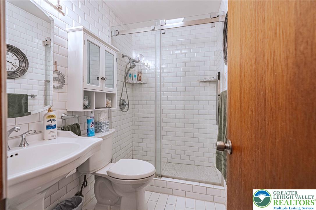 341 Lower Greenhill Road Kunkletown, PA 18058 - Photo 18 of 69 A pristine bathroom features clean subway tile walls and a spacious walk-in glass-enclosed shower.