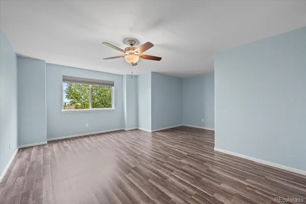 a view of a room with a fan and wooden floor
