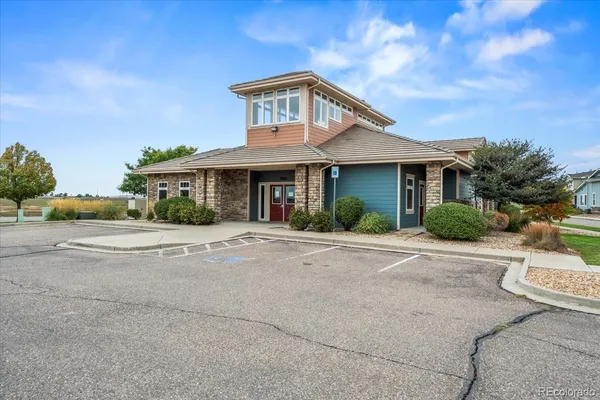 a front view of a house with a garden and trees