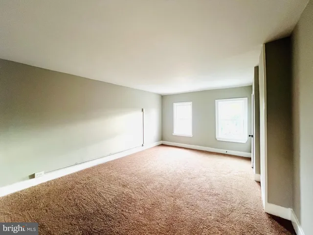 an empty room with a windows and closet