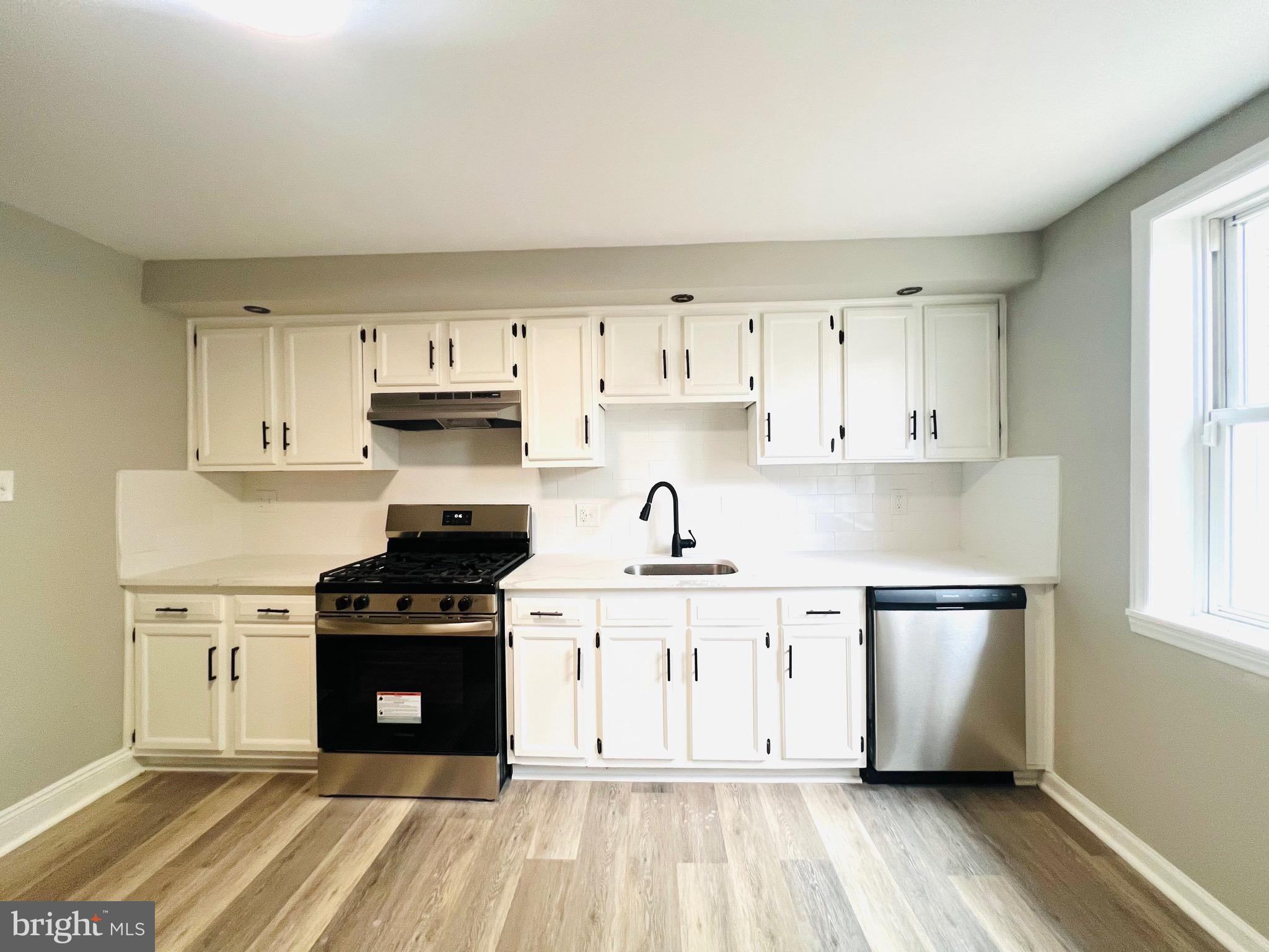 215 Middlesex Street Gloucester City, NJ 08030 - Photo 8 of 18 a kitchen with stainless steel appliances granite countertop a stove a sink and a refrigerator