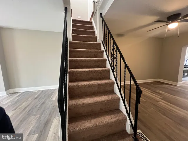 a view of staircase with white walls and railing