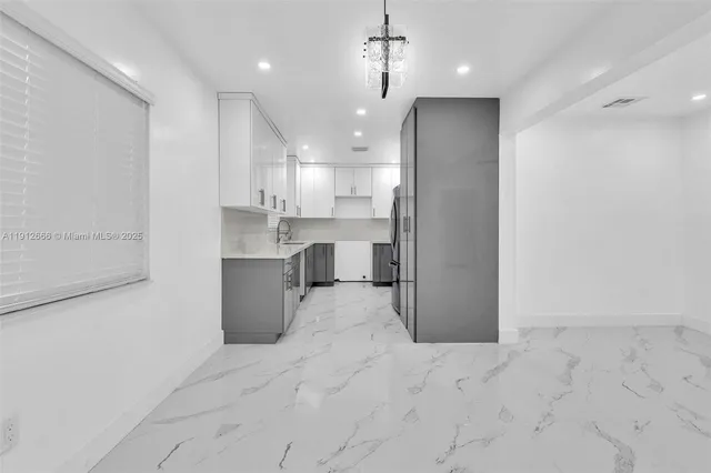 a kitchen with stainless steel appliances granite countertop a refrigerator a sink and a stove