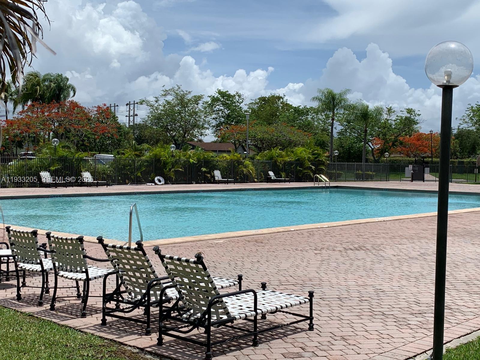 8420 Southwest 133rd Avenue Road, Unit 317 Miami, FL 33183 - Photo 6 of 22 a view of a lake with a bench and yard