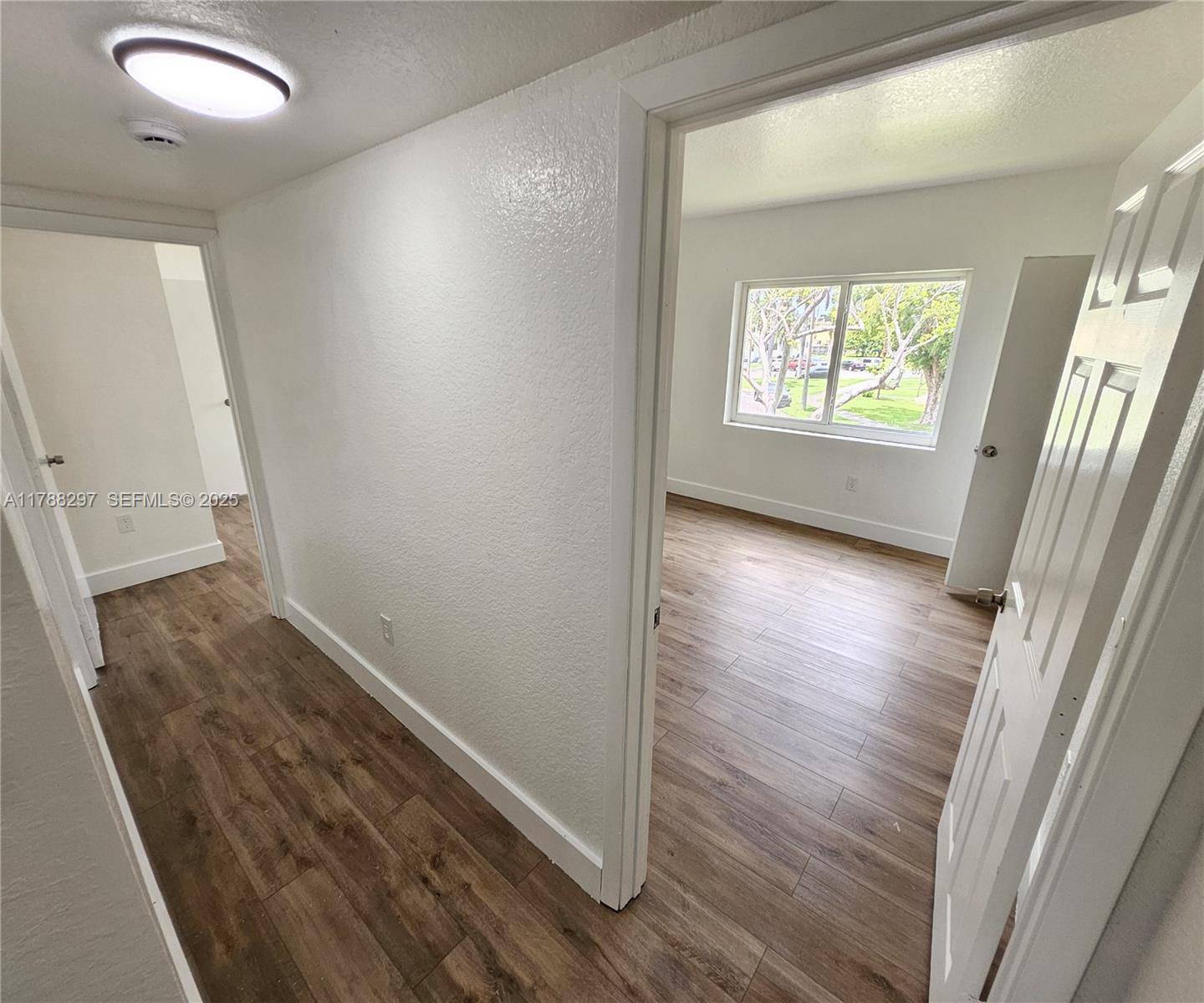 450 Northwest 84th Street, Unit 450 Miami, FL 33150 - Photo 16 of 28 wooden floor in an empty room with a window