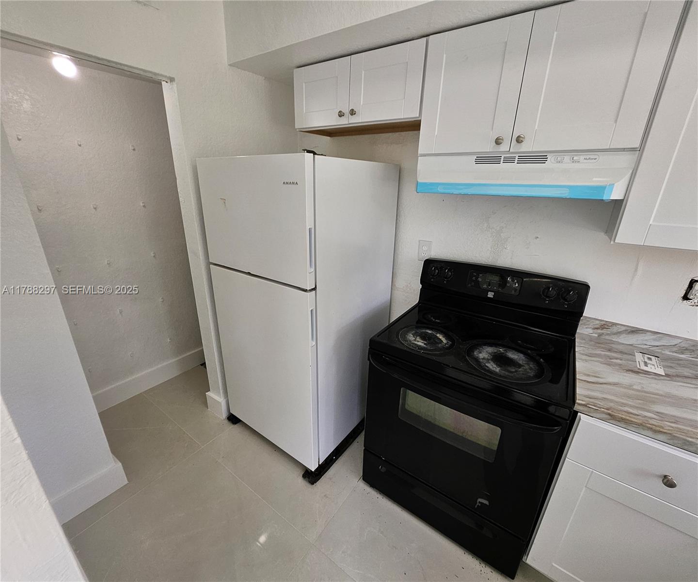 450 Northwest 84th Street, Unit 450 Miami, FL 33150 - Photo 5 of 28 a white refrigerator freezer and a stove sitting inside of a kitchen