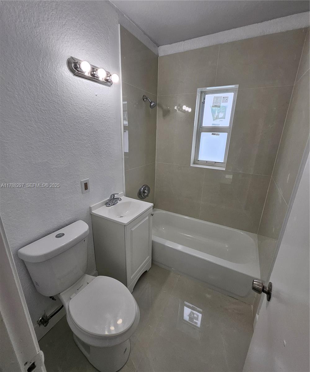 450 Northwest 84th Street, Unit 450 Miami, FL 33150 - Photo 10 of 28 a white toilet sitting next to a bath tub