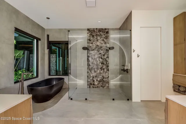 a bathroom with a double vanity sink a mirror and a bathtub