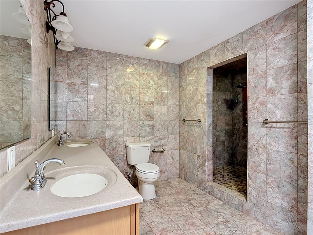 7925 Lake Mabel Loop Road Lake Wales, FL 33898 - Photo 36 of 97 a bathroom with a granite countertop sink toilet and shower
