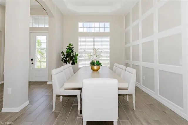 a dining room with furniture potted plants and wooden floor