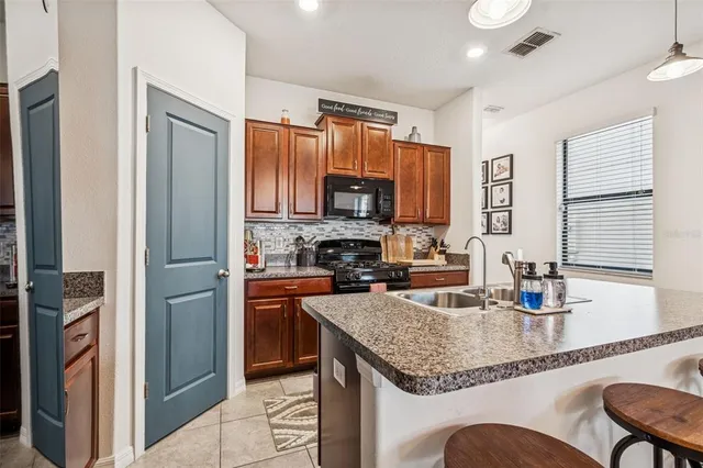 a kitchen with granite countertop stainless steel appliances a refrigerator stove microwave and sink