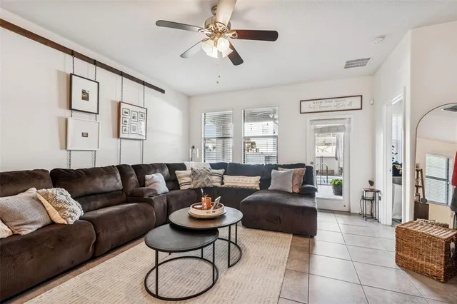 a living room with furniture a ceiling fan and a rug