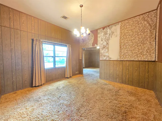 a view of a livingroom with a chandelier fan and a window