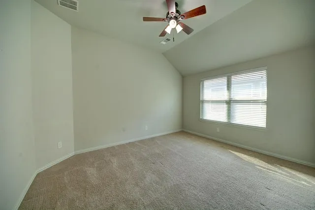 an empty room with a window and a fan