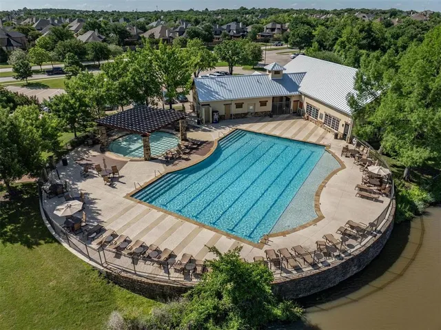 an aerial view of a house with swimming pool and lake view