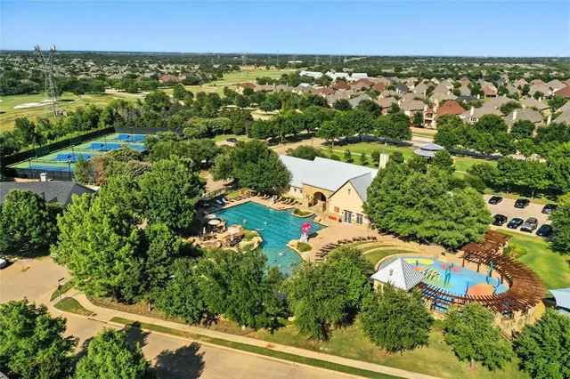 an aerial view of residential houses with outdoor space and trees