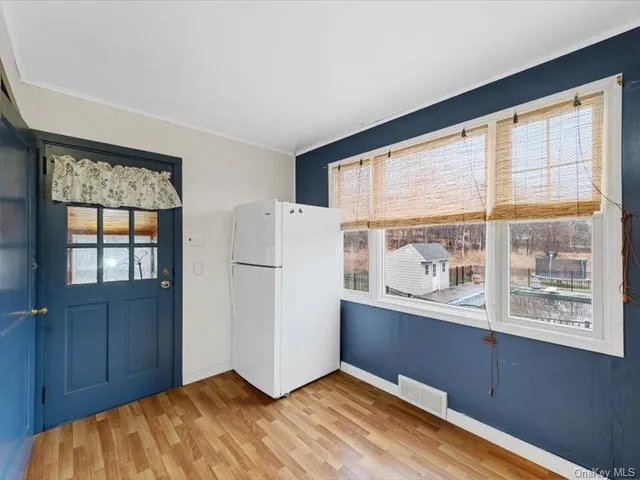 a view of a kitchen with wooden floor and a window
